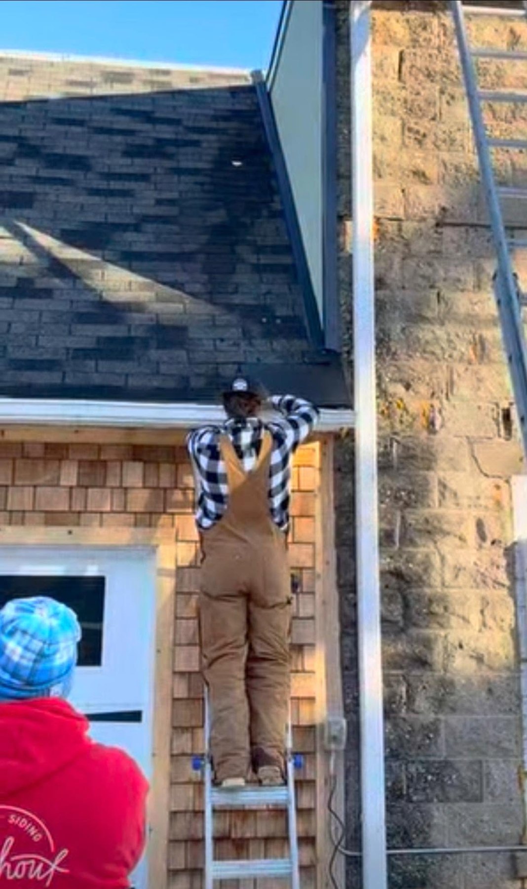 Roofer on a ladder at the roof edge